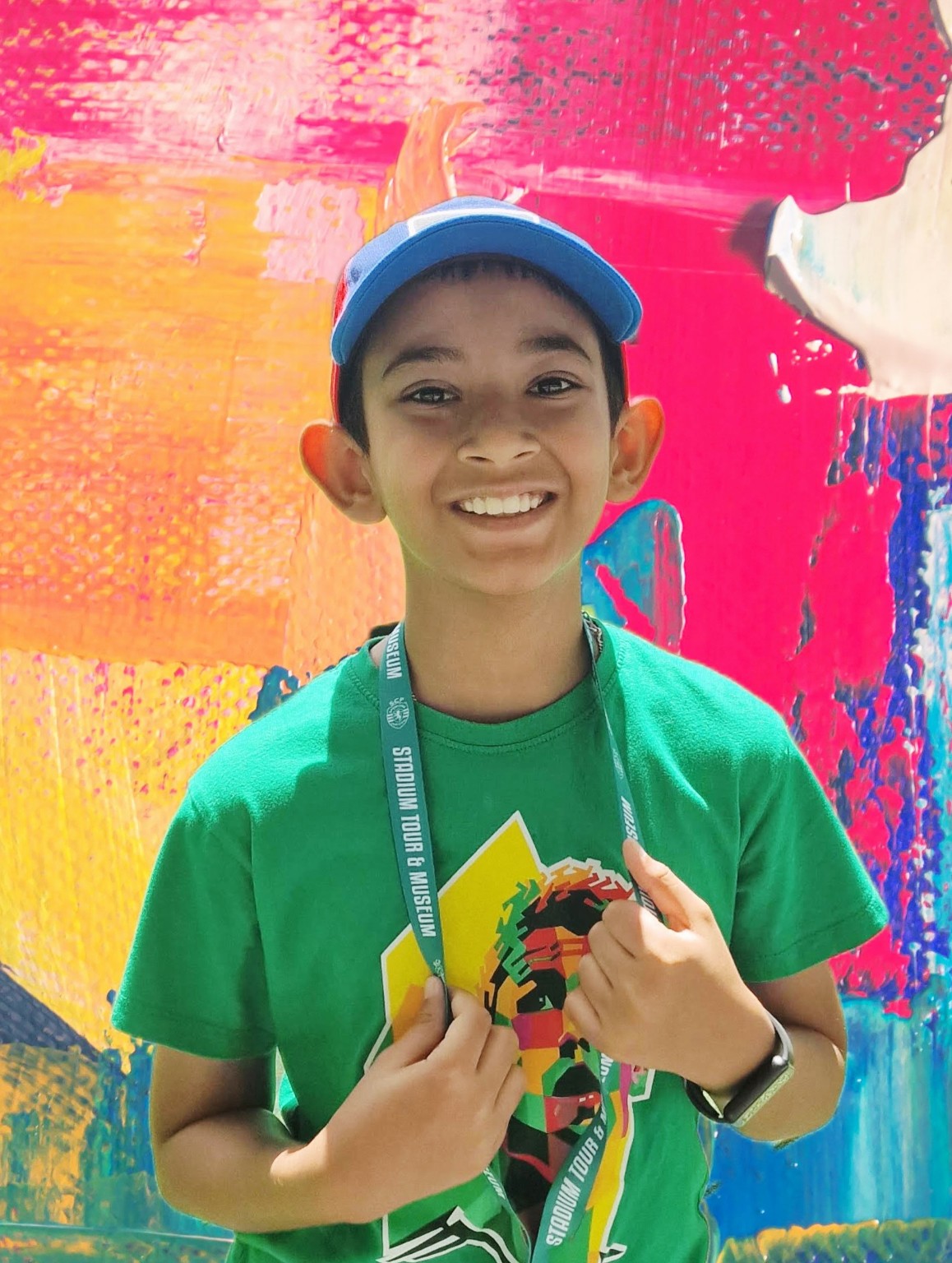 Dripto smiling in front of colourful abstract artwork.